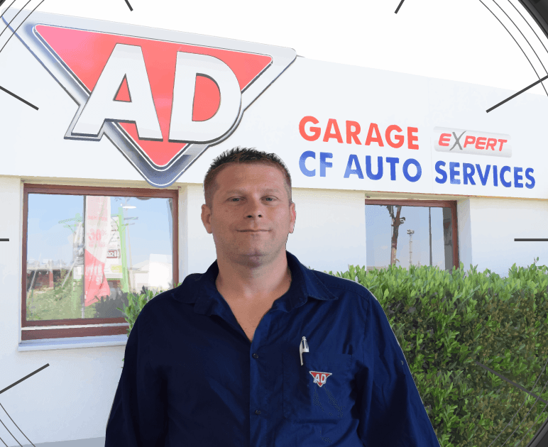 Un homme se tient devant un garage publicitaire