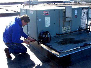 Man working on a unit — Jefferson City, MO — Superior Services Inc. Working on a unit — Jefferson City, MO — Superior Services Inc.