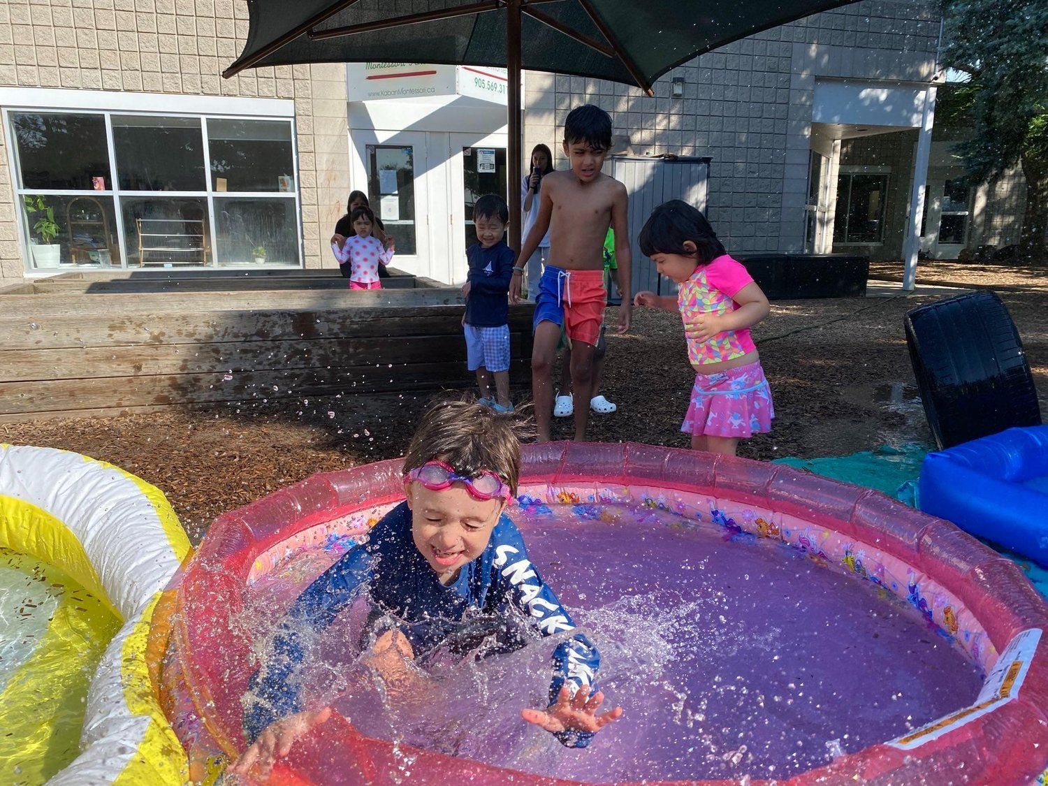 A group of children are playing in an inflatable pool.