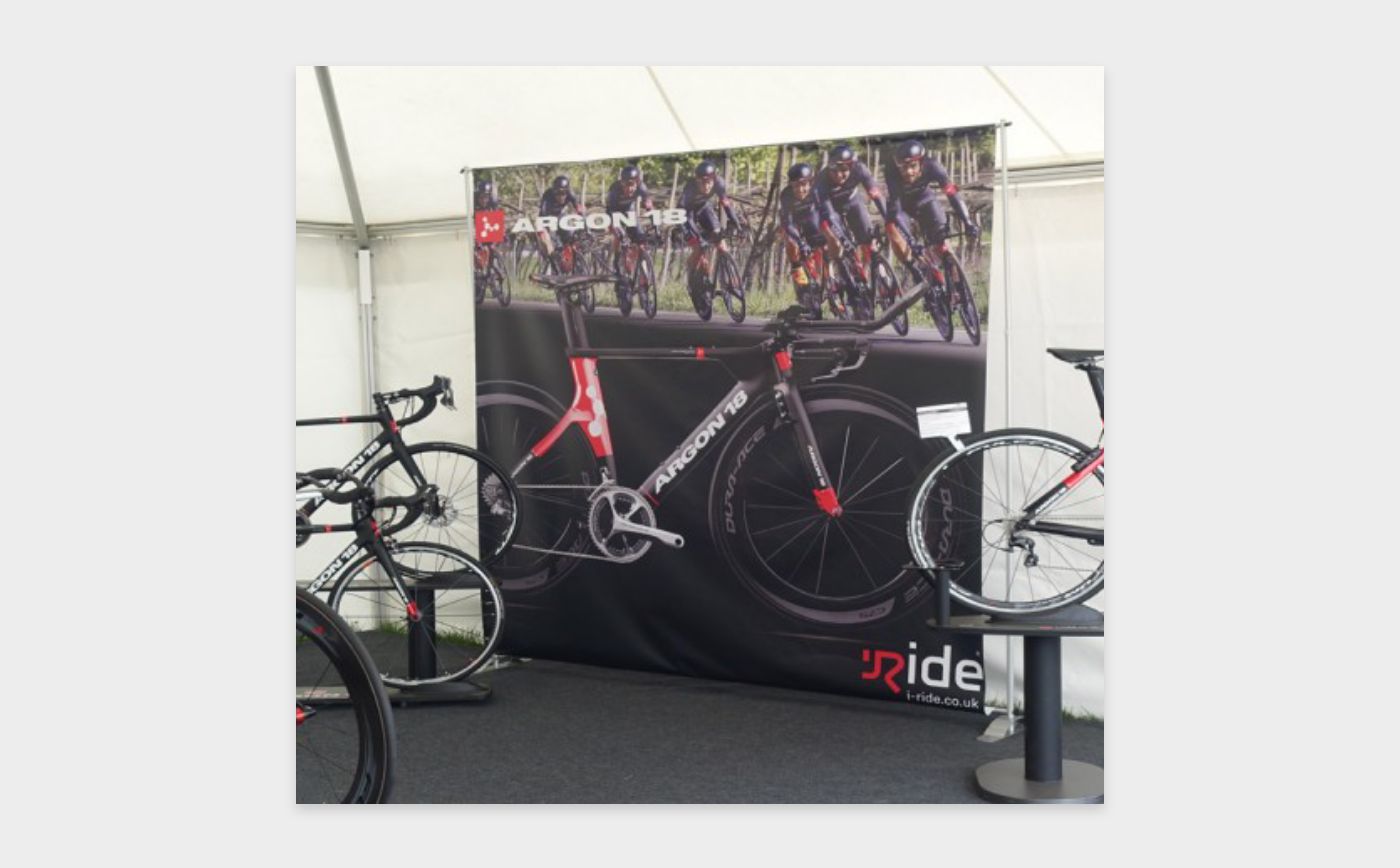 A bicycle is displayed in front of a sign that says ride