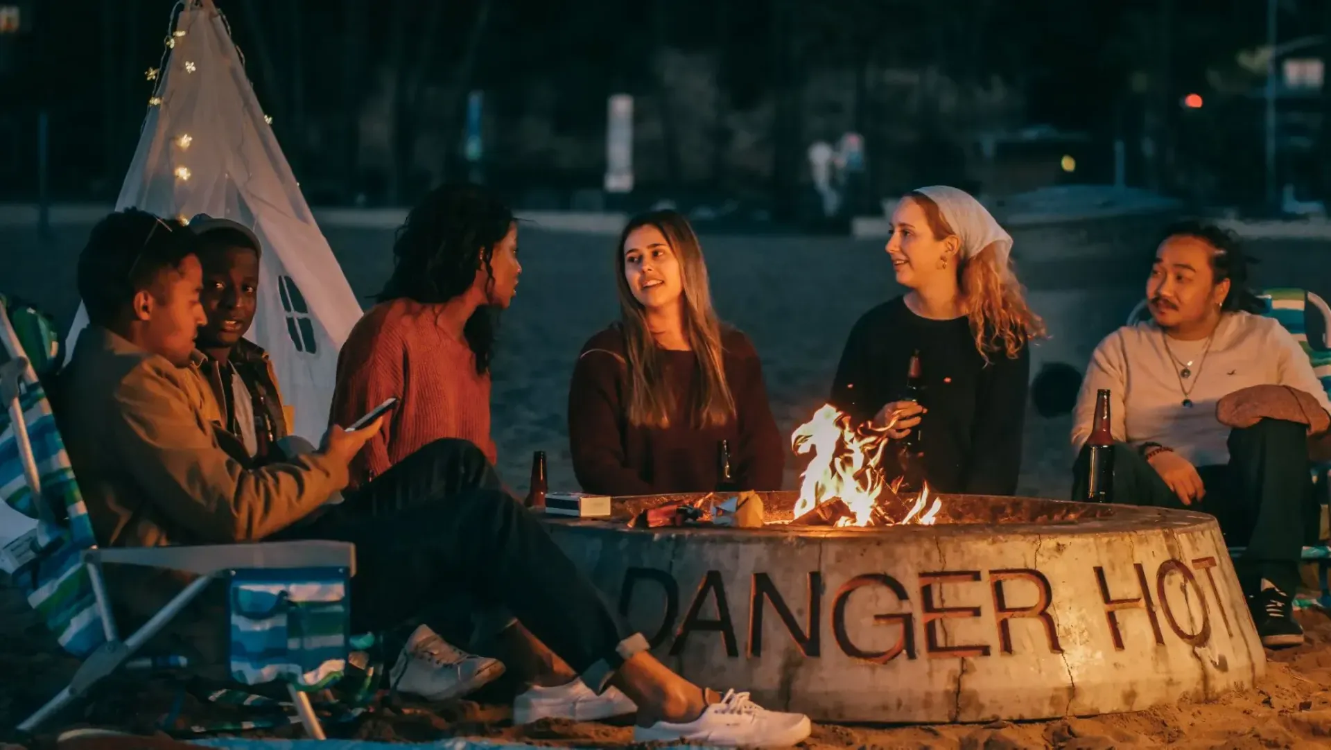 A group of friends spending time around a fire pit