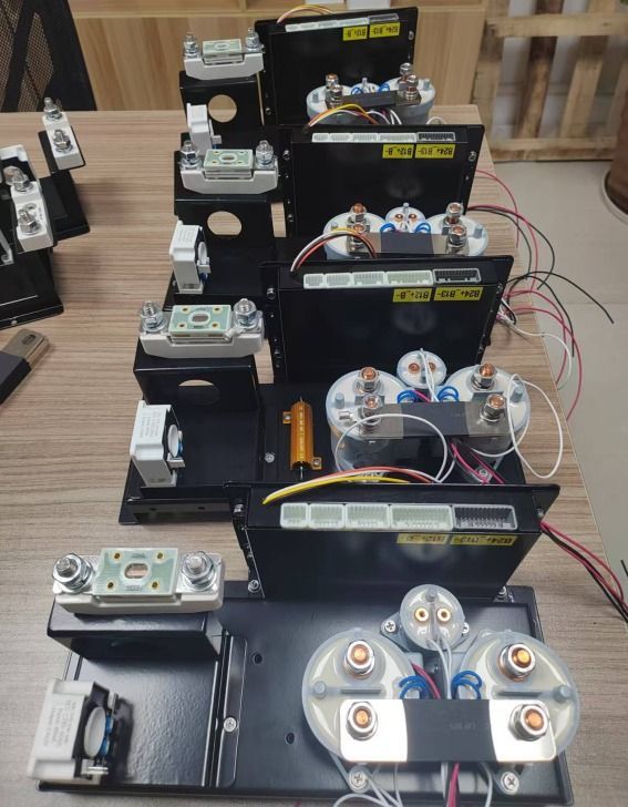 Montajes electrónicos de sobremesa apilados, con cables, interruptores y pequeños módulos dispuestos en filas sobre un banco de trabajo.