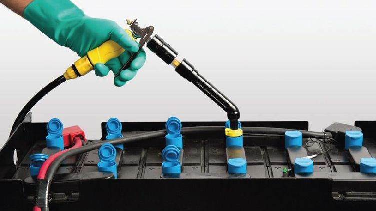 Celdas de batería soldadas a mano con guantes en un paquete de baterías negro con conectores azules.