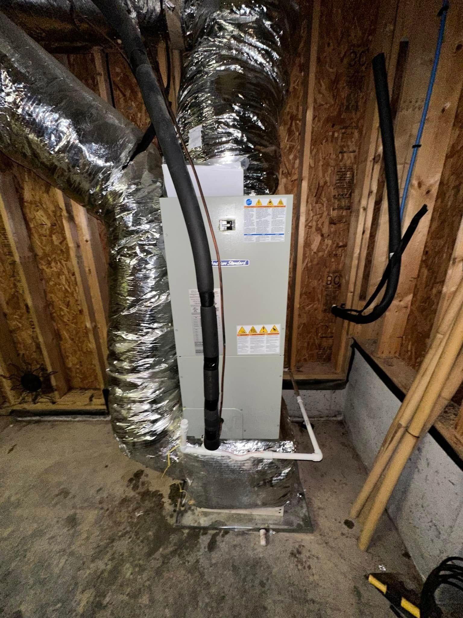 HVAC furnace in unfinished basement with large insulated ductwork and exposed wooden walls