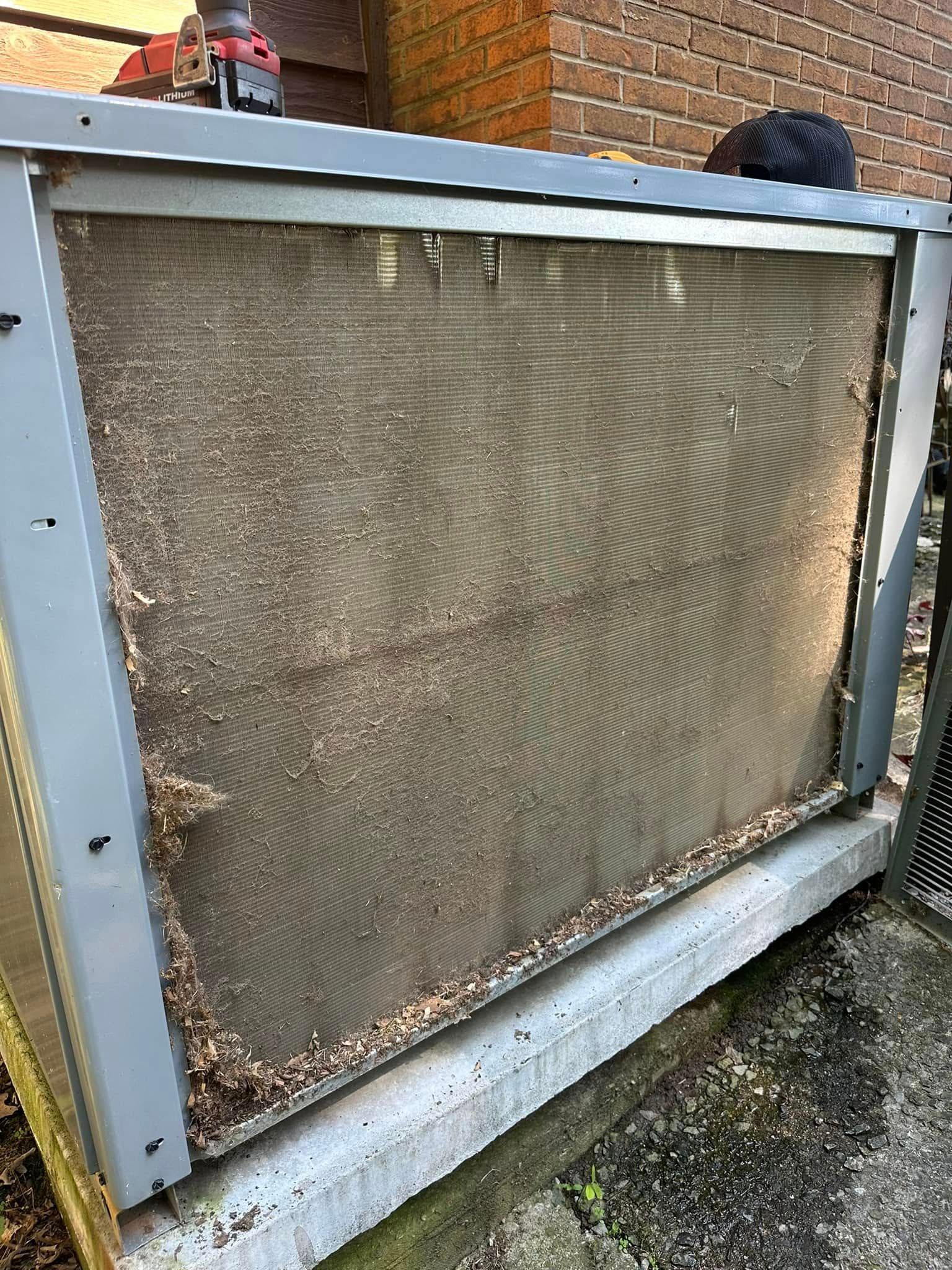 Weathered metal mesh panel in a blue frame leaning outdoors on a wet surface