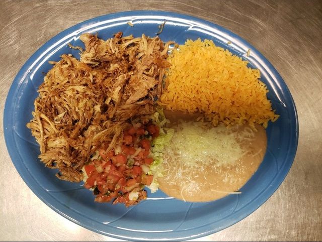 Blue plate with shredded meat, yellow rice, rice and beans, and a small tomato salsa.