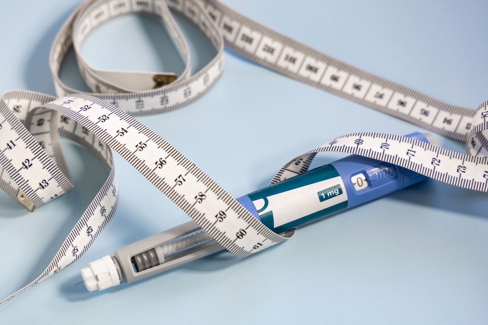 A measuring tape and an insulin pen on a table