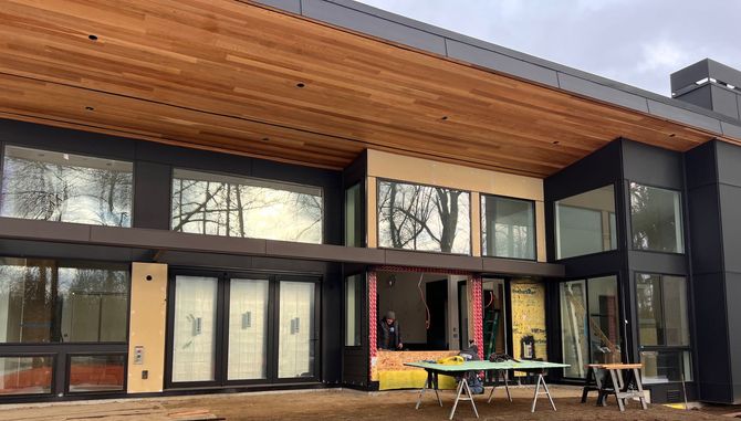 Image of a house under construction with large glass windows and doors.