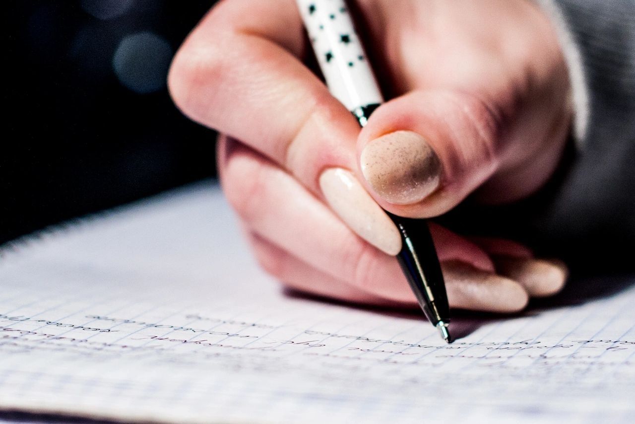 A Person Is Writing On A Piece Of Paper With A Pen — Phoenix Mandorla In Rockhampton City, QLD