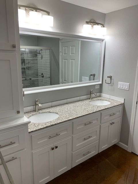 A bathroom with two sinks and a large mirror.
