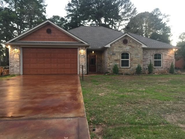 A house with a large garage and a driveway in front of it.