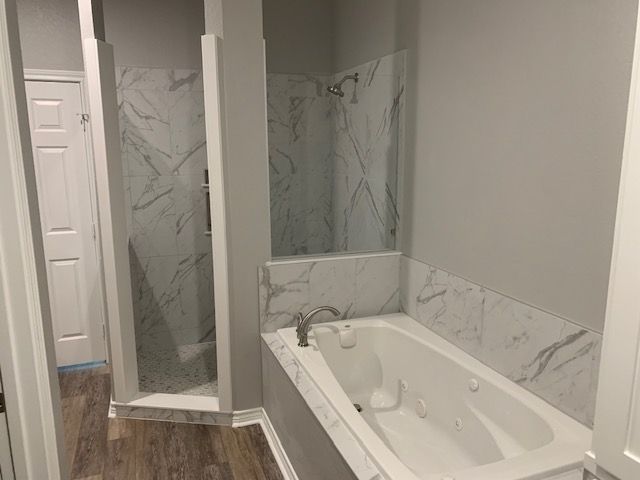 A bathroom with a bathtub and a walk in shower.