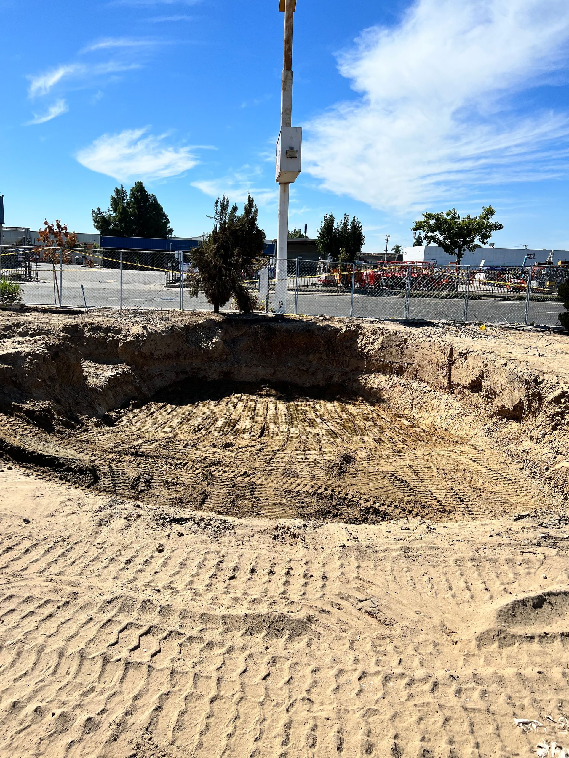 A large hole in the ground with a crane in the background