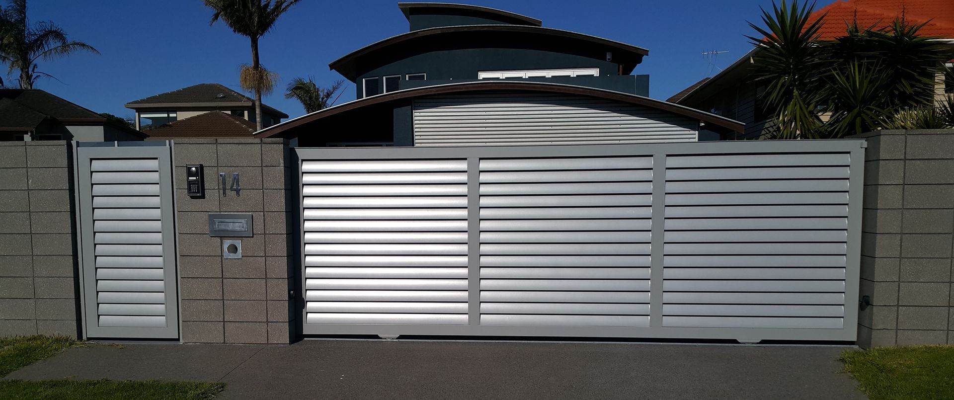 A house with a sliding gate and a mailbox