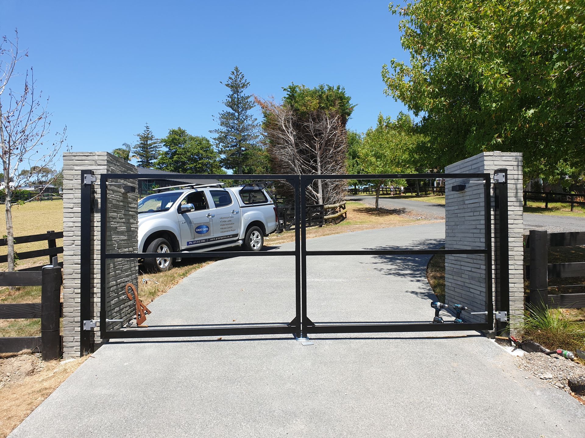 A white truck is parked in front of a gate.