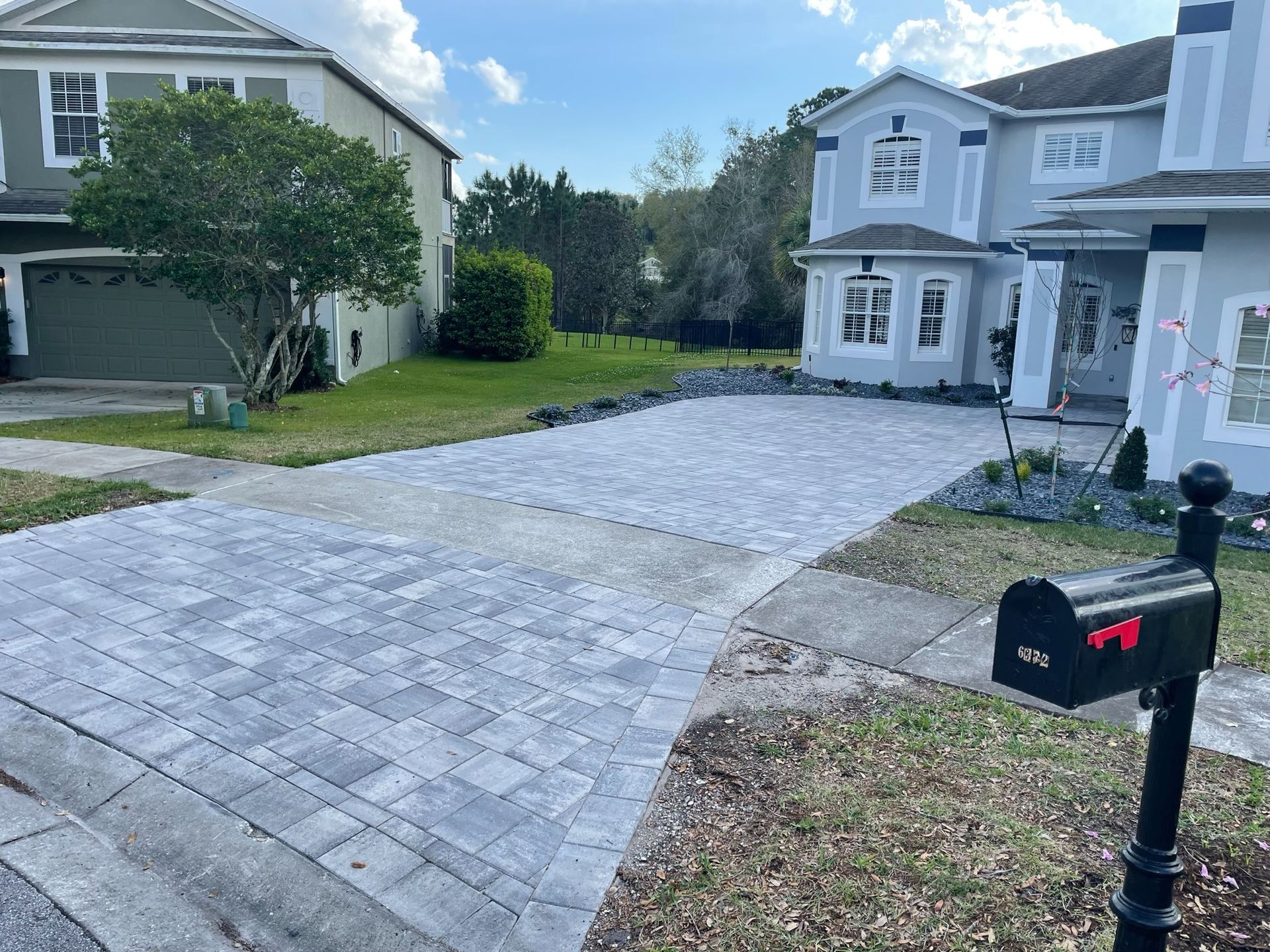 Suburban house driveway with paver stones and a black mailbox in front