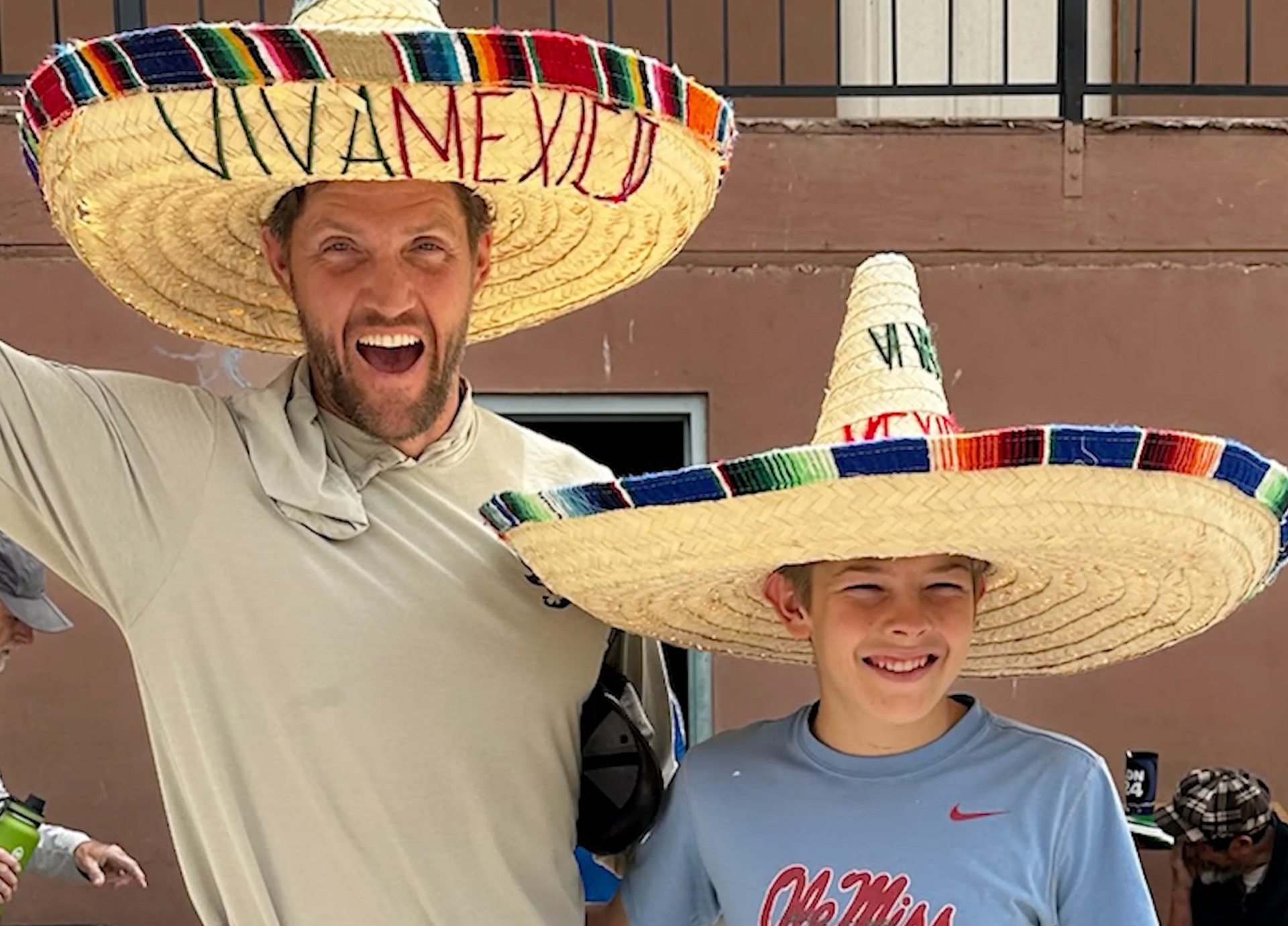 A man and a boy wearing sombrero hats that say viva mexico