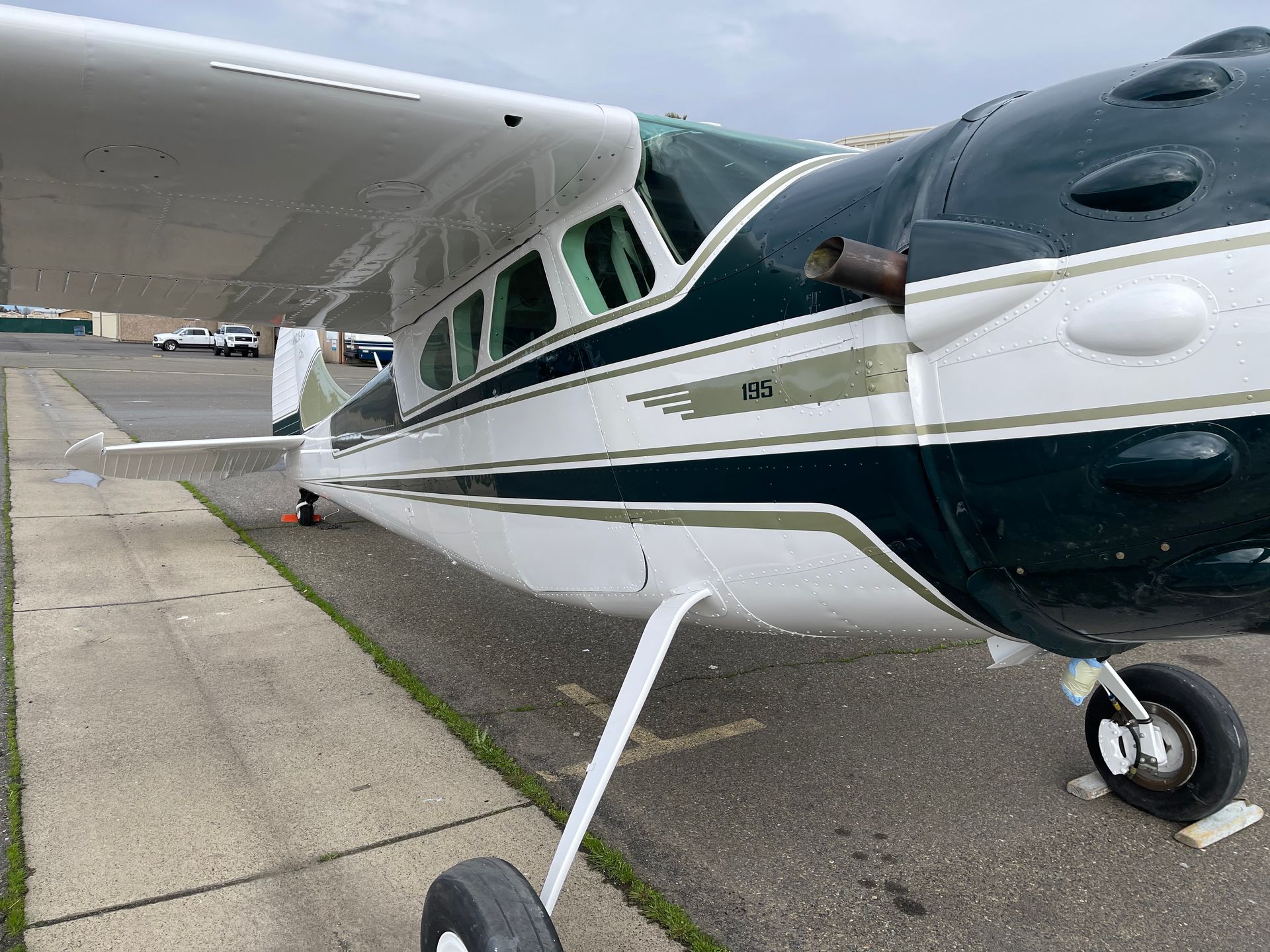 Blue airplane on tarmac, facing camera with propeller, wings extended.