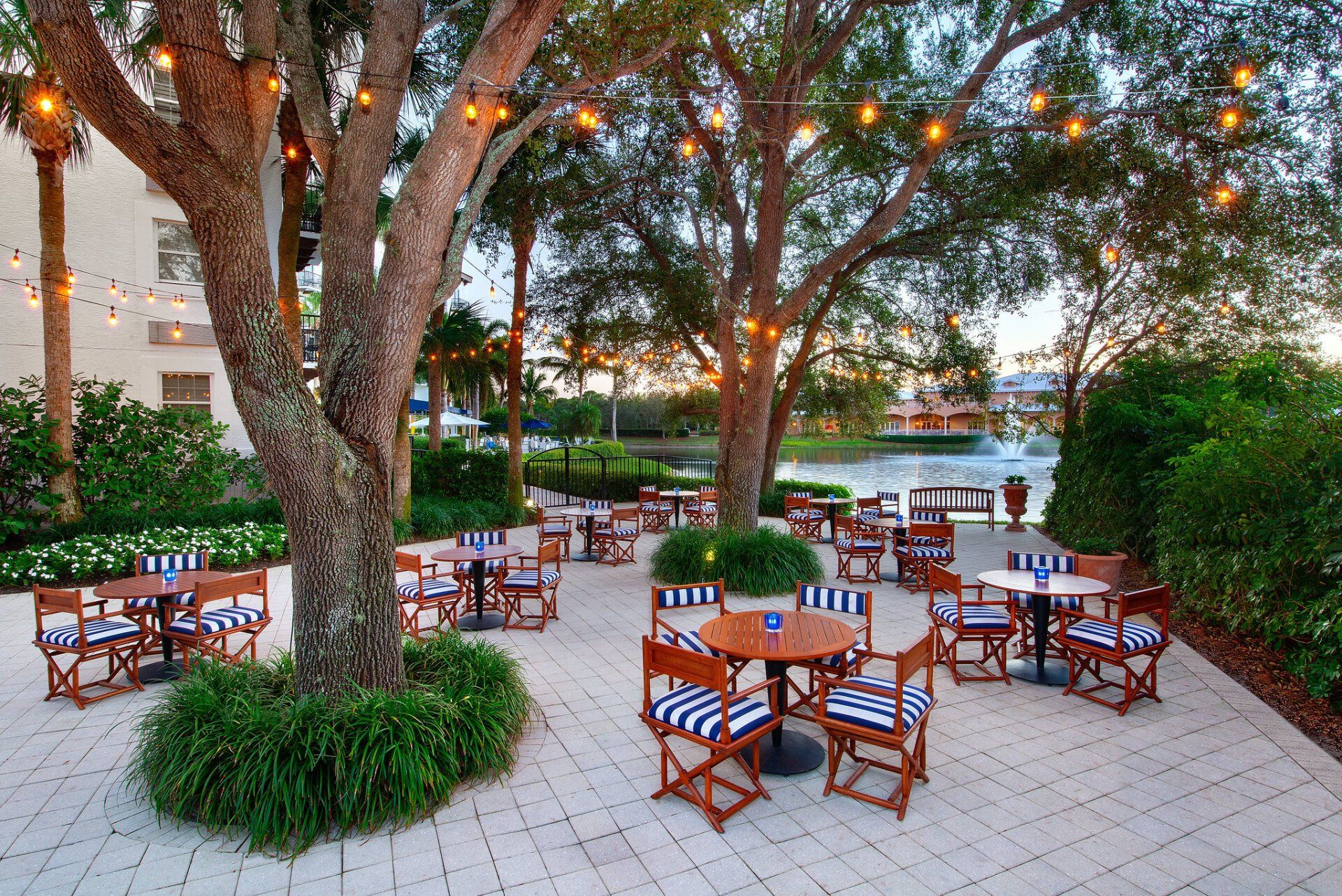 A patio with tables and chairs under a tree