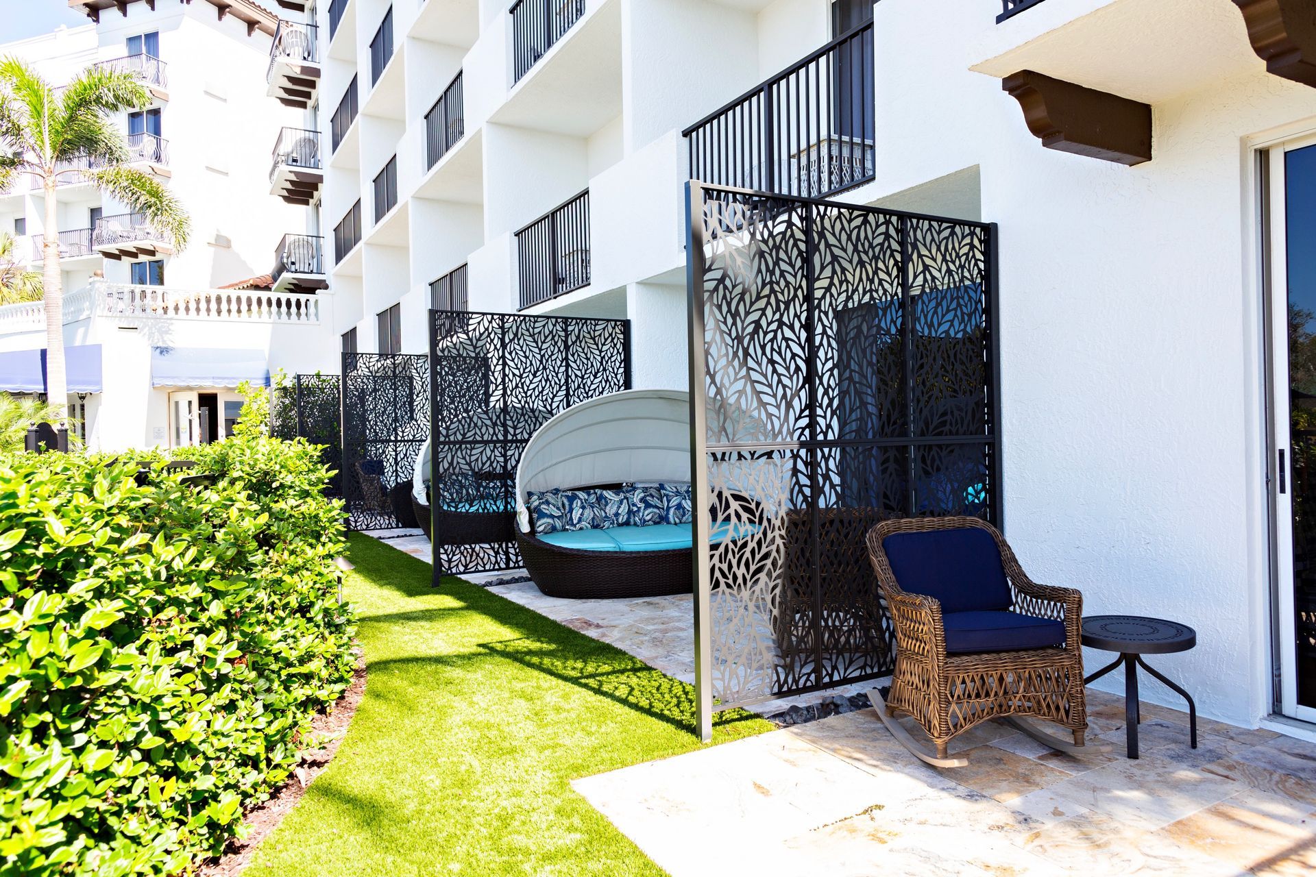 A balcony with a chair and a table in front of a building