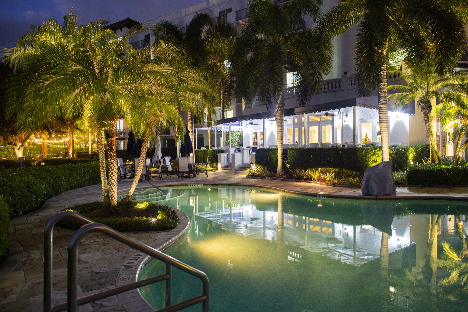 A large swimming pool is lit up at night
