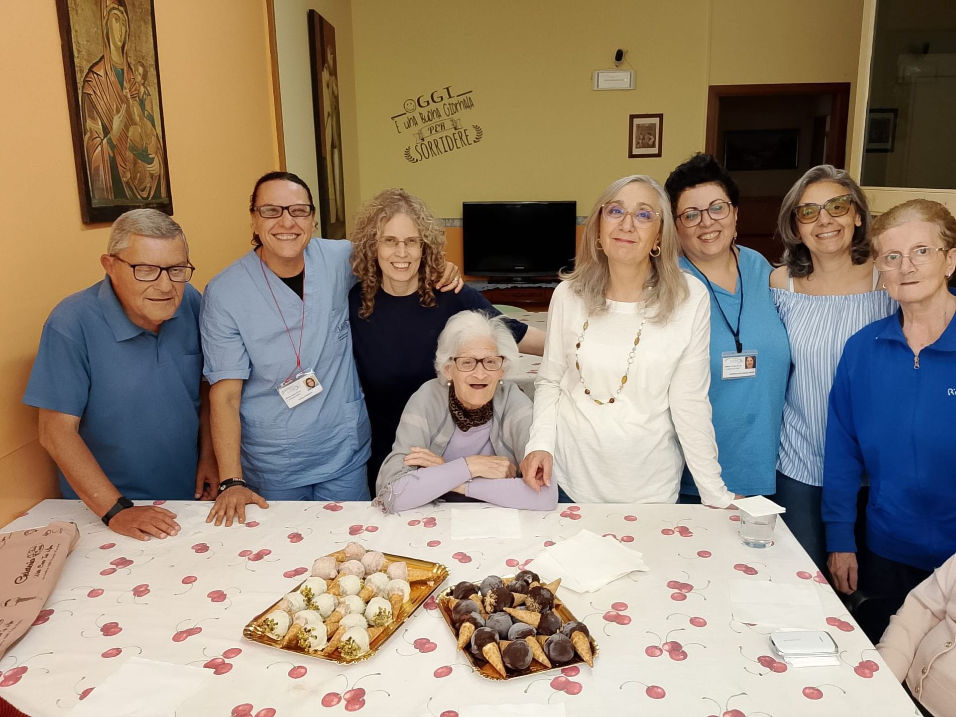 Il gruppo si è riunito attorno a un tavolo con dei pasticcini in una sala comune.