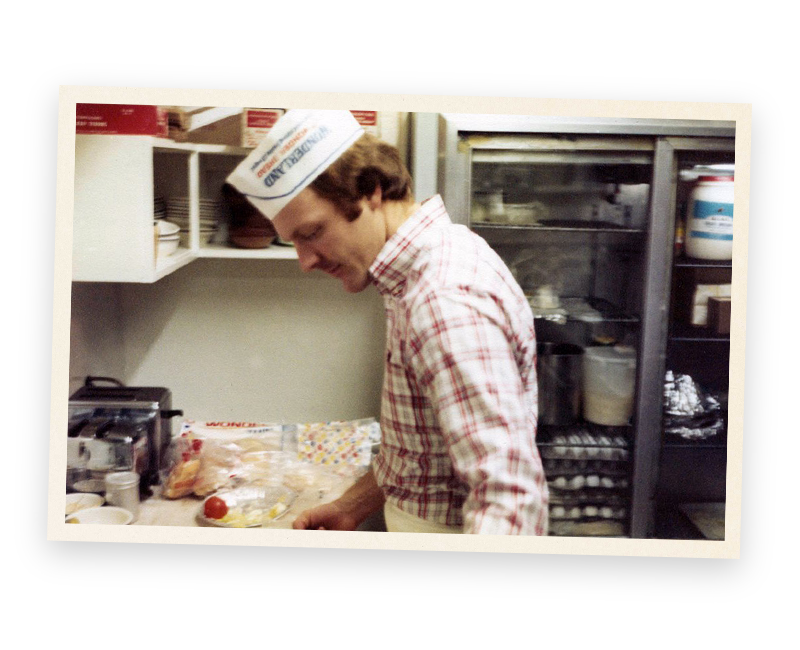 A man wearing a chef 's hat is preparing food in a kitchen