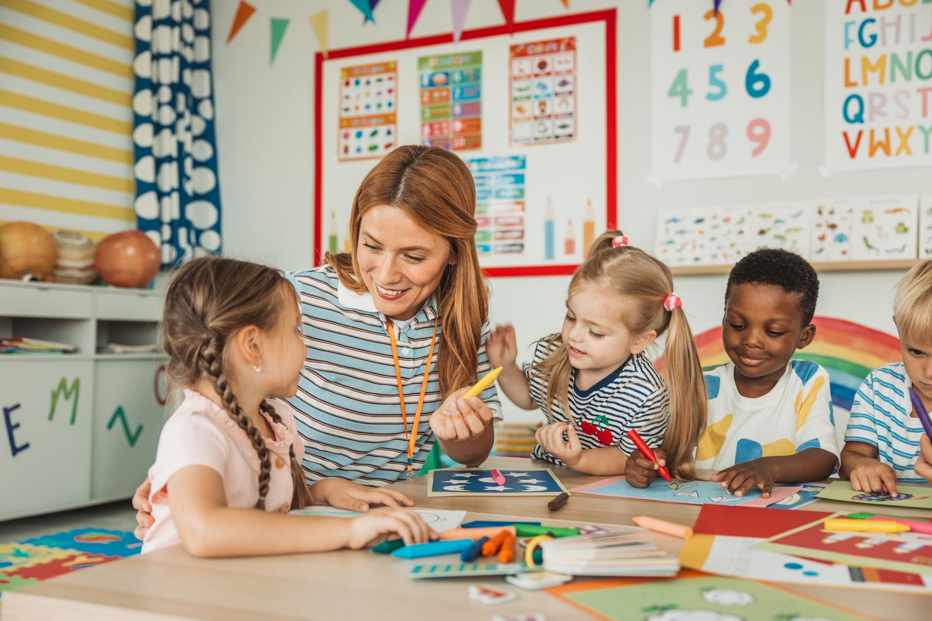 Teacher drawing with a group of children at kindergarten. Teacher drawing with a group of children at kindergarten.
