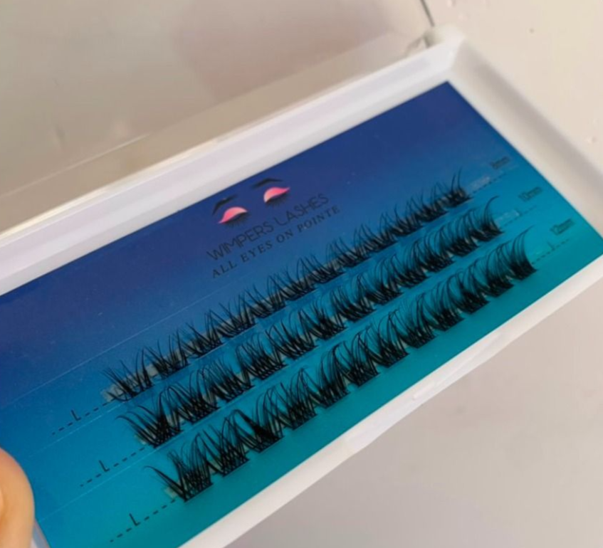 Box of black individual eyelash clusters on blue backing.