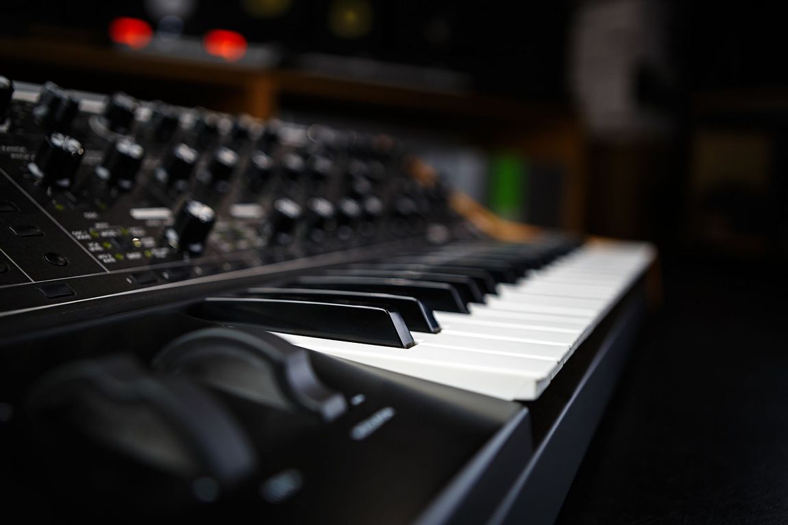 Keyboard synthesizer with black keys and control knobs.