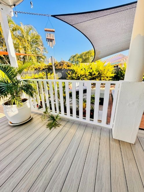 A Deck With A White Railing And Potted Plants — Ward's Aluminium in Bowen, QLD