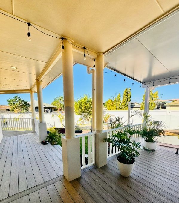 A Porch With Potted Plants And A White Railing — Ward's Aluminium in Bowen, QLD