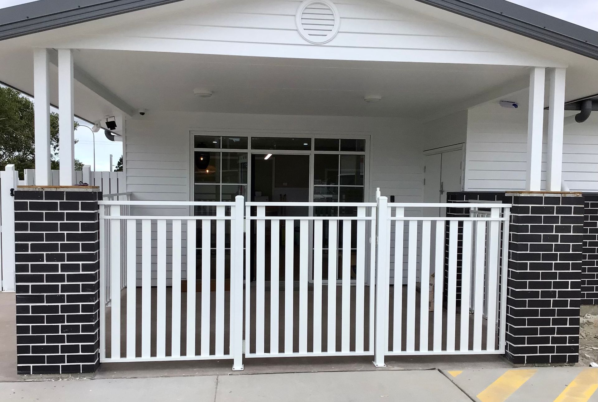 A white fence with a building behind — Ward's Aluminium in Garbutt, QLD