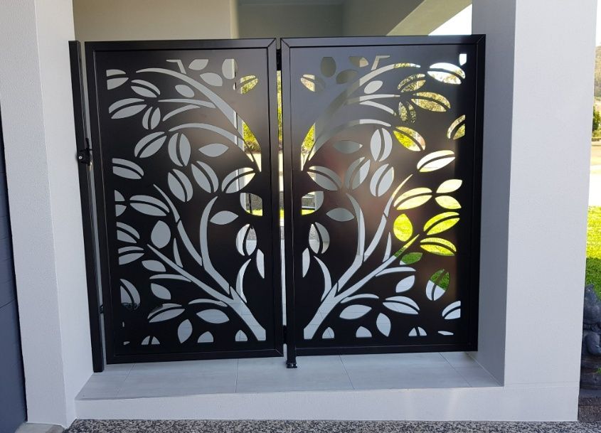 A Black Metal Gate With A Tree Design On It — Ward's Aluminium in Garbutt, QLD