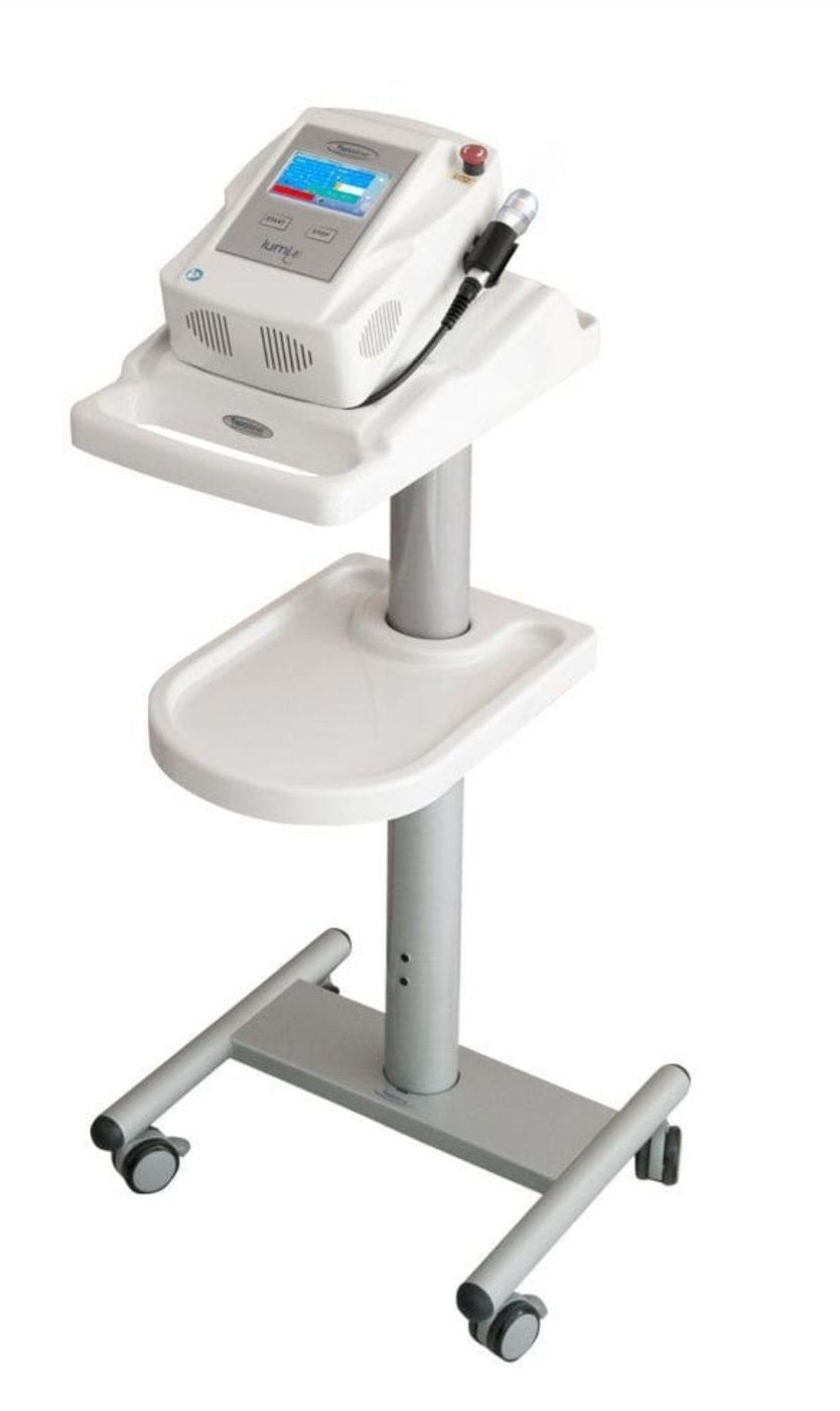 Dispositivo medico mobile su supporto con ruote, dotato di touchscreen e ripiano.