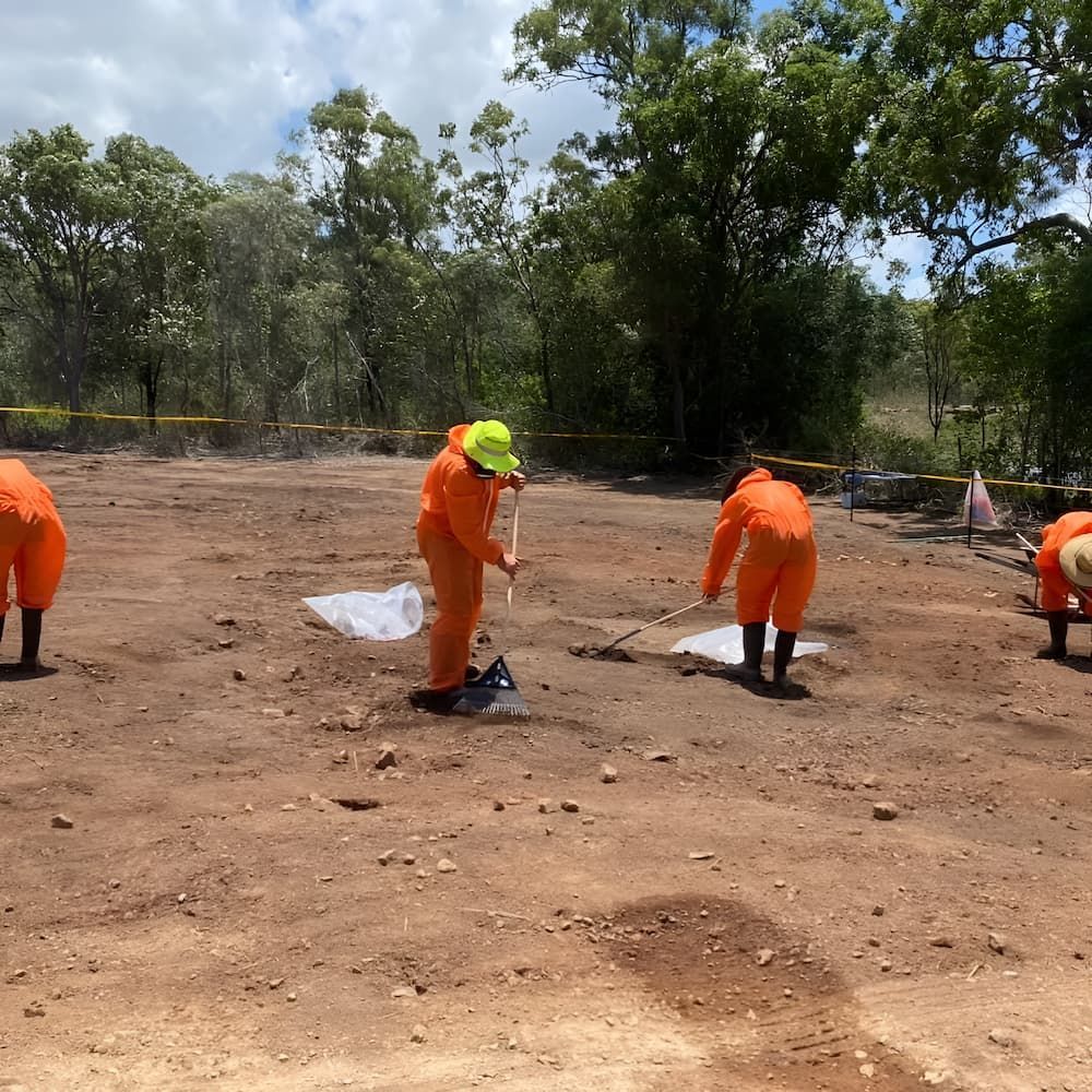 Three People in Orange Jumpsuits Are Working in a Dirt Field — Veramax Industries in Park Avenue, QLD