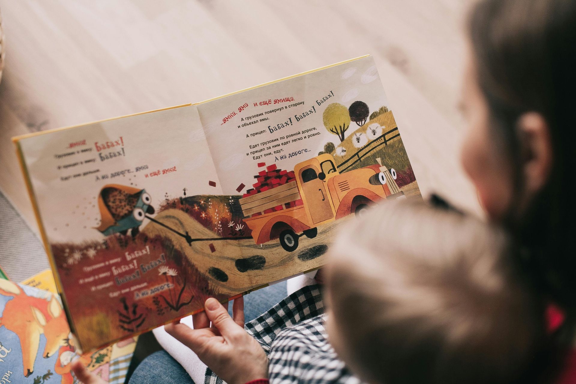 Uma mulher está lendo um livro para um bebê.