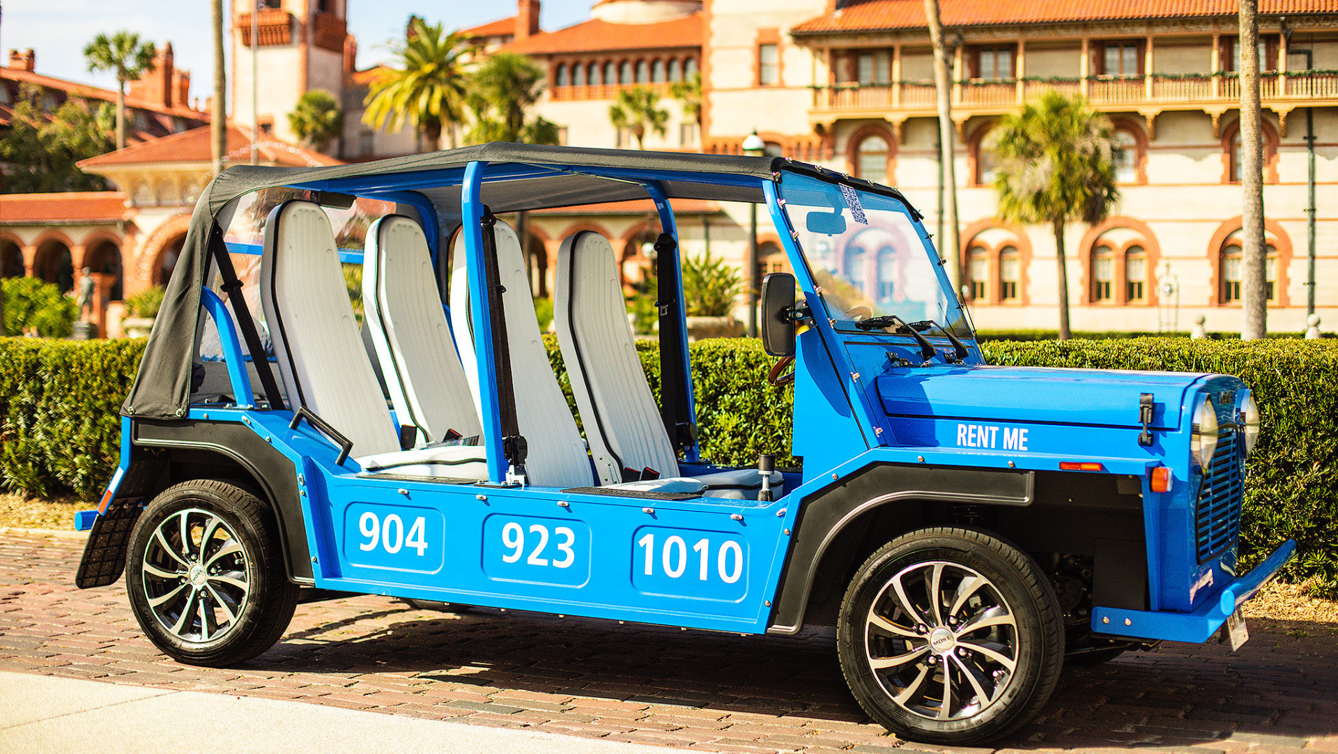 A blue moke for rent is parked in front of Flagler college in St. Augustine, Florida