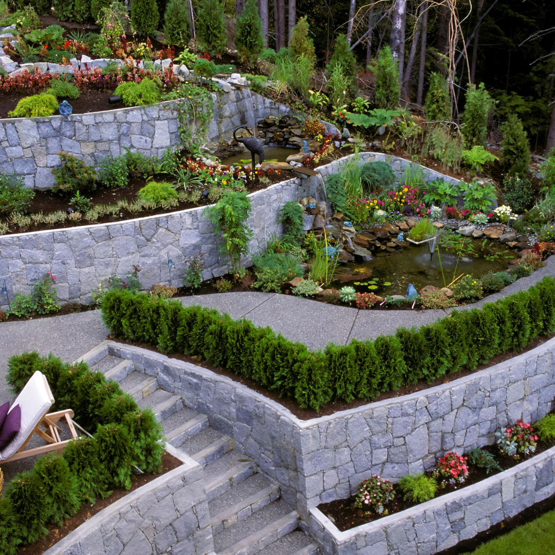 A lush green garden with a stone wall and stairs