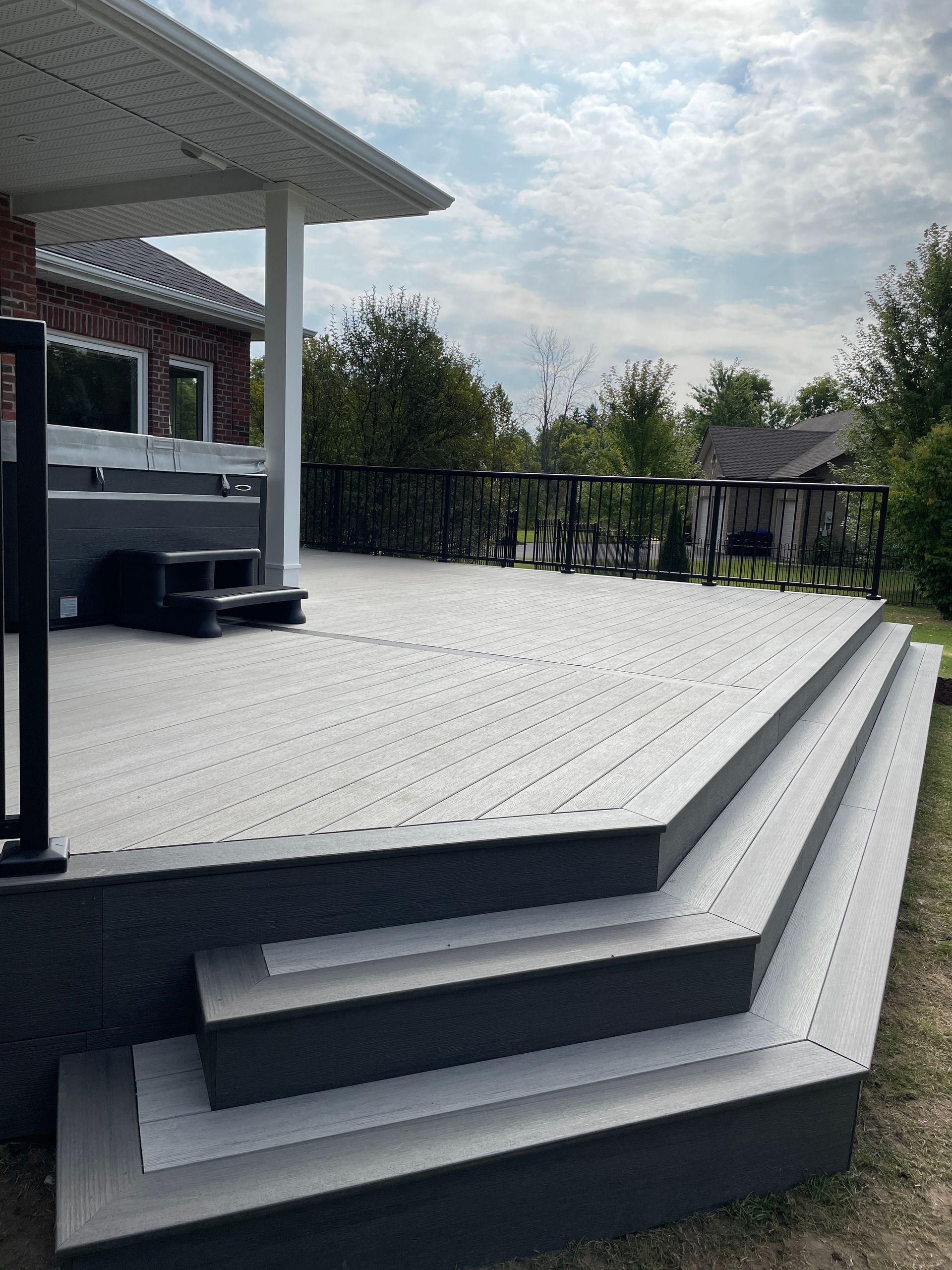 Custom built angled composite steps with hot tub in background