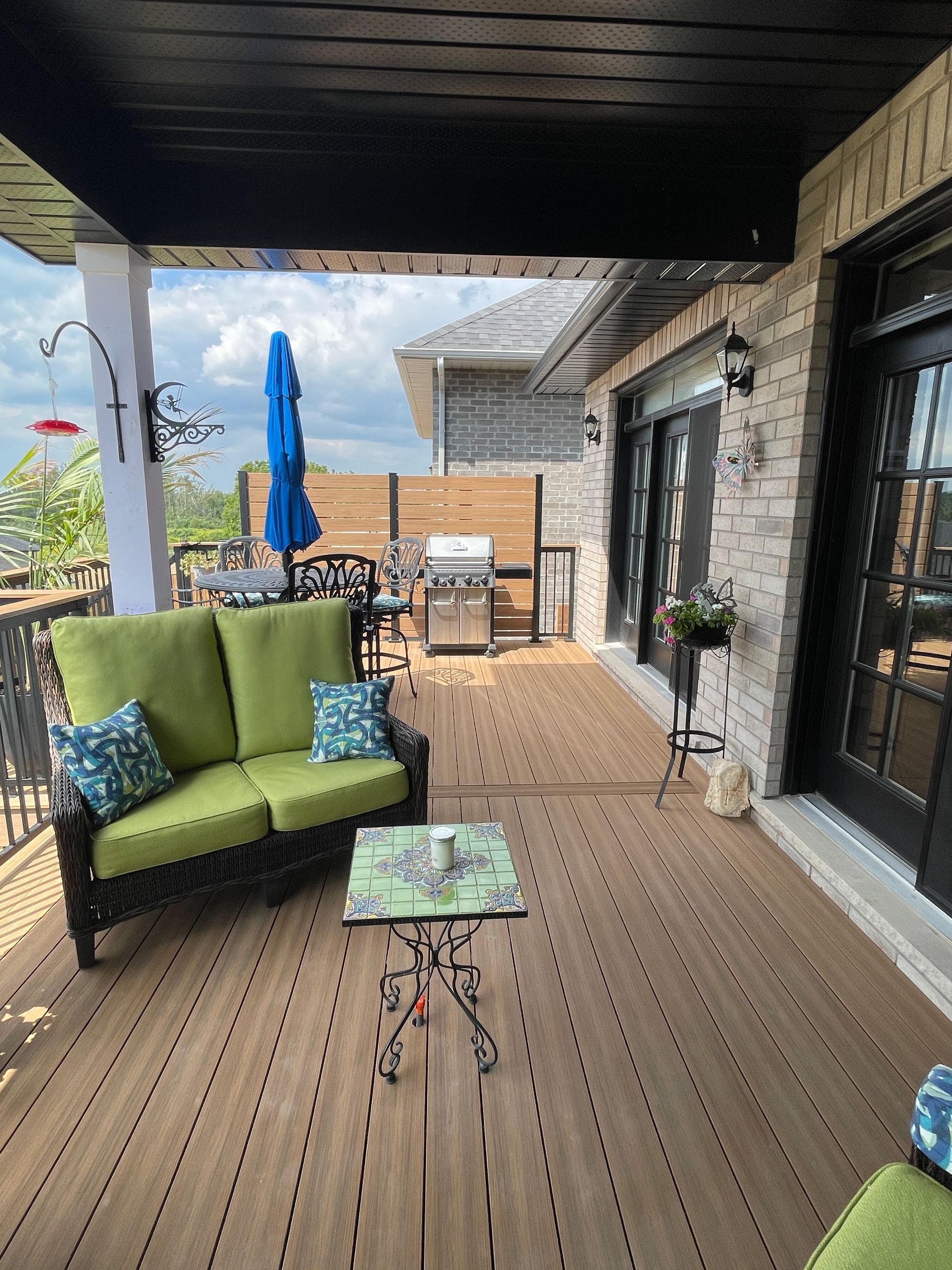 Composite covered deck with privacy wall