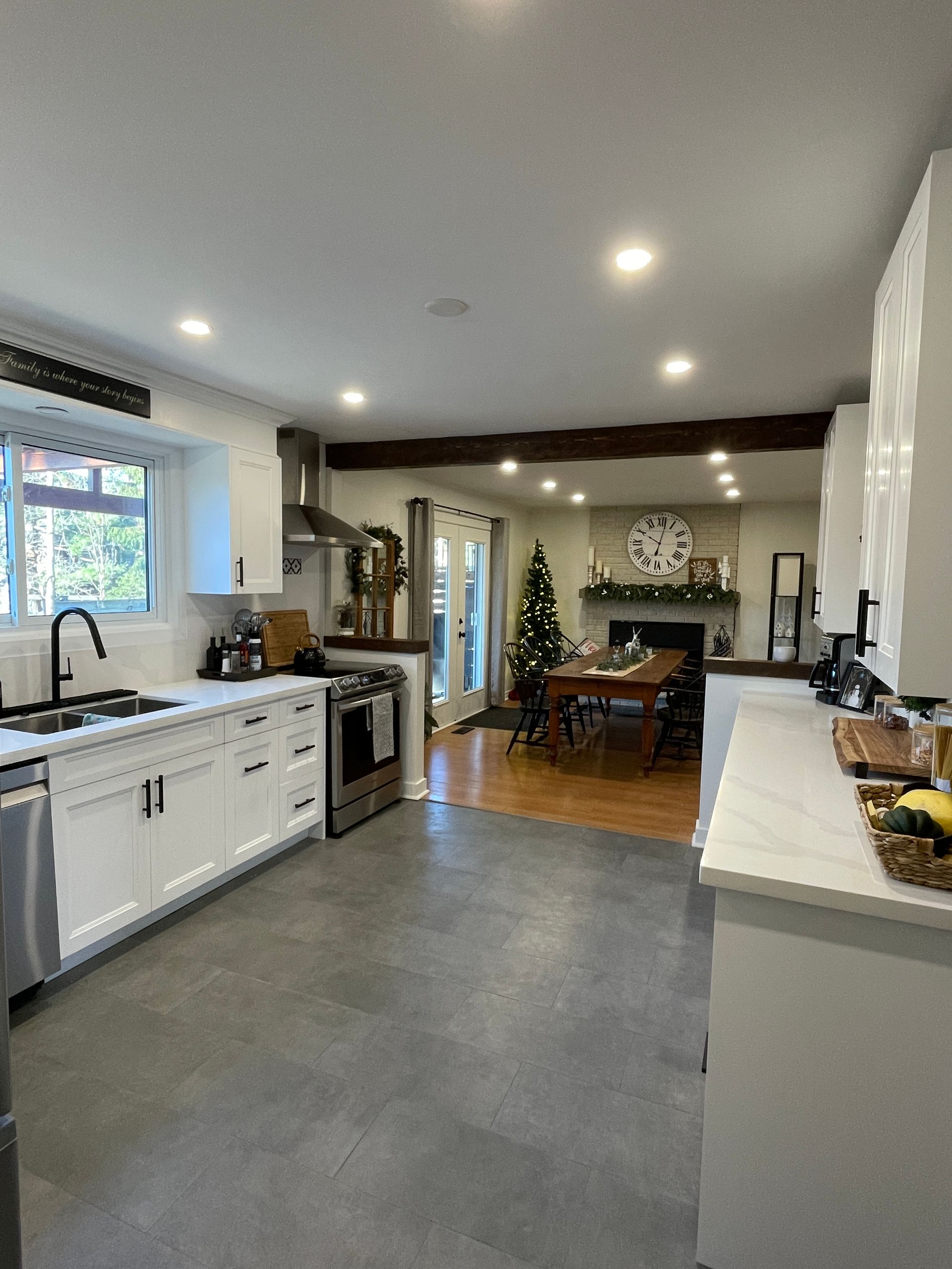 Modern kitchen with white cabinets, stainless steel appliances, and a view into the dining area.