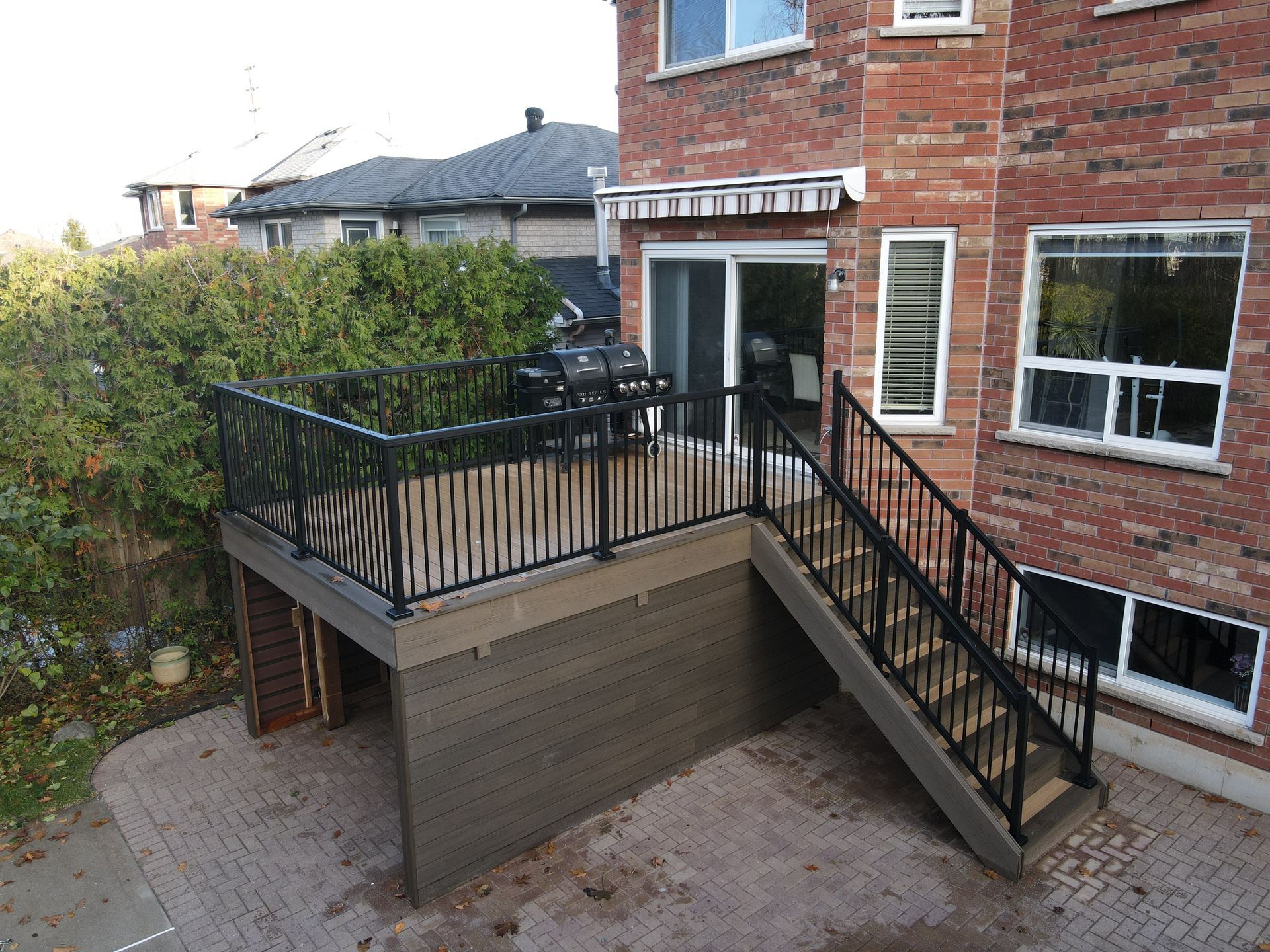 Brown and tan PVC deck with black aluminum railings and staircase