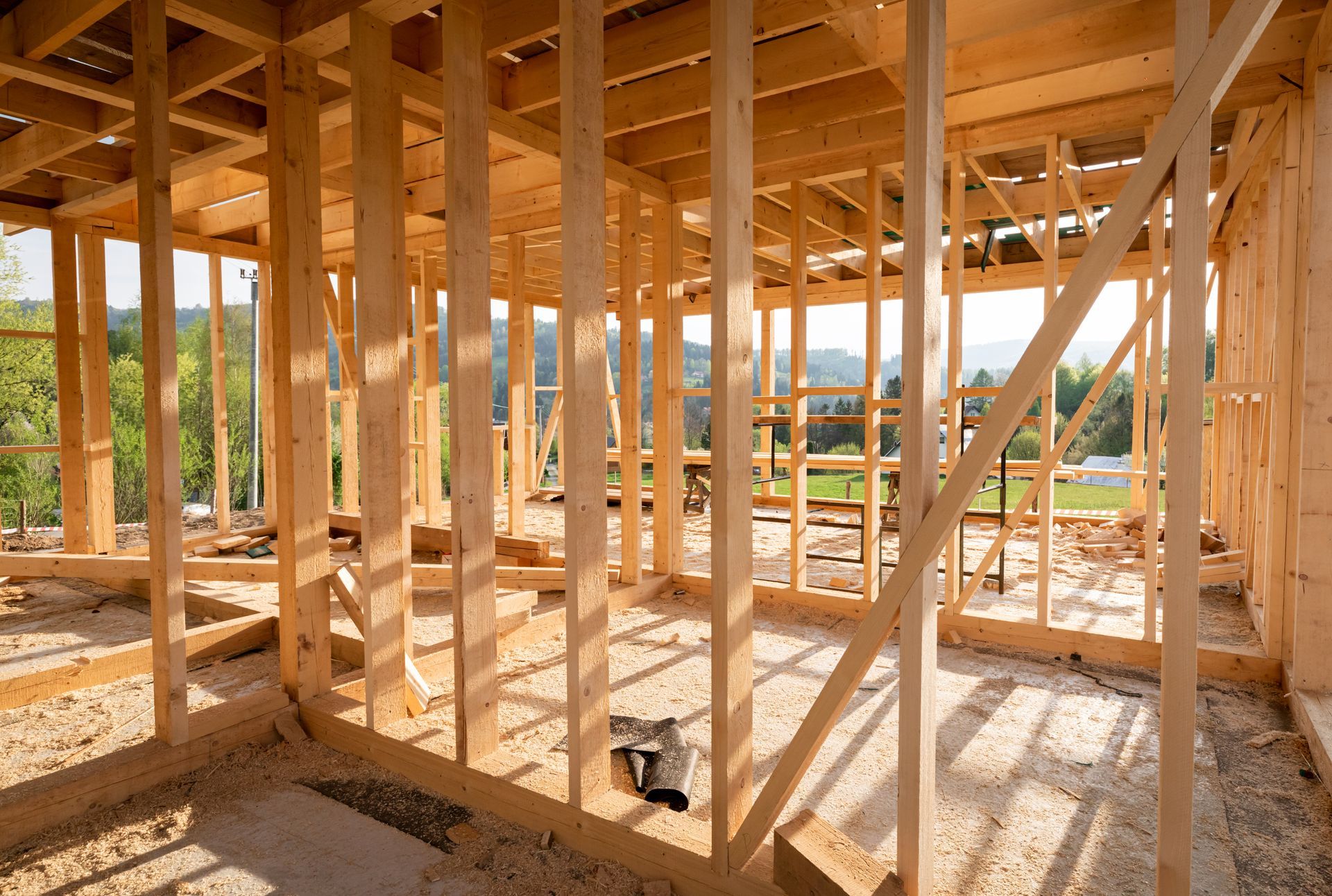 Wooden framework of a building under construction, view of interior with beams and studs.