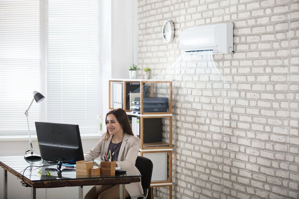 A Woman Is Sitting at A Desk in Front of A Computer in An Office — Danzair Refrigeration & Airconditioning in Casino, NSW