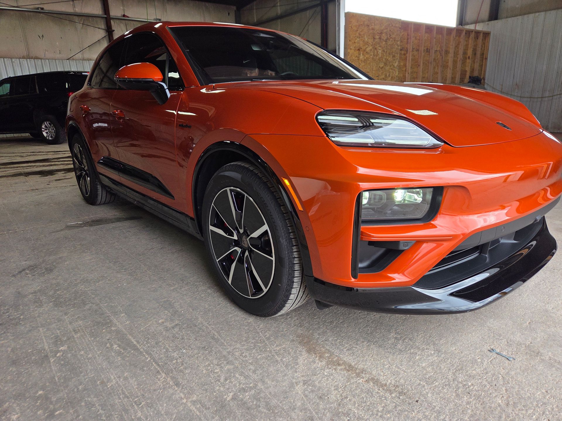 Orange Porsche electric SUV parked inside a garage.