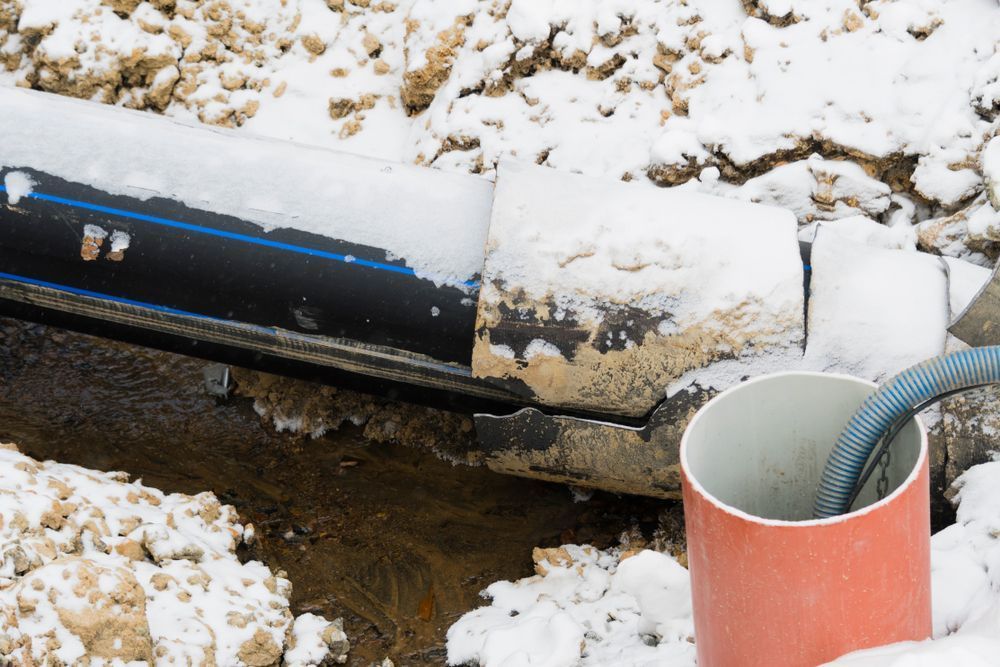 A Red Pipe is Sitting in the Snow Next to a Black Pipe — Treatwater & Plumbing Pty Ltd in North Mackay, QLD