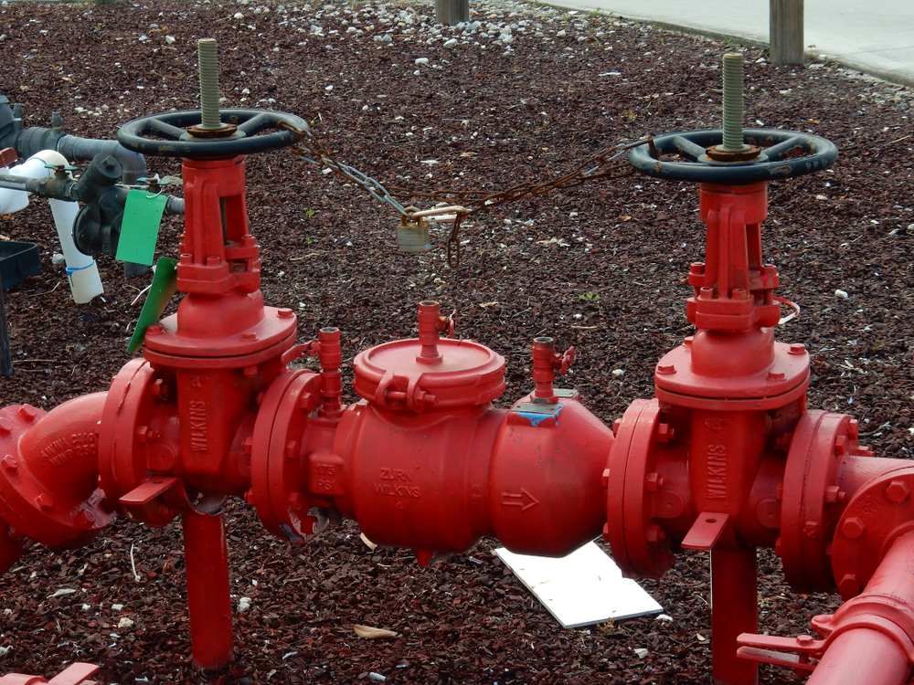 A Bunch of Red Pipes With Valves on Them — Treatwater & Plumbing Pty Ltd in North Mackay, QLD