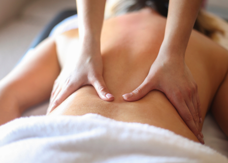 A woman is getting a massage on her back to reduce stress.