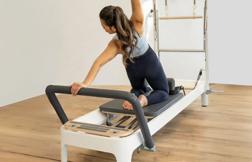 A woman is holding a pilates ring in her hands during a private Pilates session.